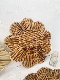 two wicker baskets sitting on top of a white table next to an empty glass bottle