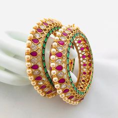 Kundan Openable Sabyasachi Bangles/Ruby Kundan Pearl Punjabi Openable Statement Bangles with Green Meenakari/Jadau Rajwadi Bangles/ Indian Bollywood Bangles Pair of 2 bangles Made in brass metal with 22k Gold Plating along with Ruby CZ Stones, Kemp stones and Mint Green Meenakari Width- Approx .65 Inches Available in 2.4, 2.6 and 2.8. Refer size reference image. Openable Bangles High quality and craftsmanship Ready to ship from VA, USA All our jewelry pictures are taken in natural light with no Traditional Bracelets With Zari Work For Celebration, Traditional Bracelet With Zari Work For Celebration, Traditional Chandbali Bangle With Cutdana, Multicolor Zari Work Bangle, Traditional Multicolor Chandbalis With Zari Work, Kundan Meenakari Bangle, Ceremonial Multicolor Kundan Chandbalis, Diwali Celebration Bracelets With Zari Work, Multicolor Meenakari Temple Jewelry