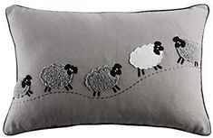 a gray pillow with black sheep on it