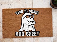 this is some boo sheet door mat on the floor next to a potted plant