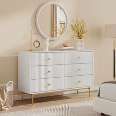 a white dresser sitting in a bedroom next to a bed with a mirror on top of it