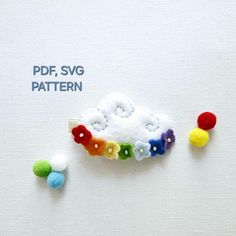 the brooch is made up of different colored pom - poms and beads