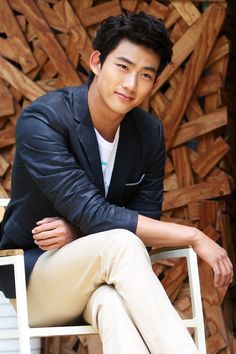 a young man sitting on top of a white chair