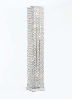 a tall glass vase with many lights on the top and bottom part, in front of a white background