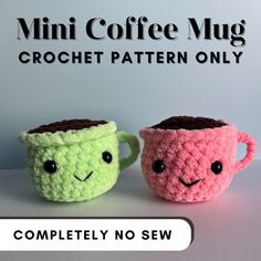 two crocheted coffee mugs with faces on them, one is pink and the other is green