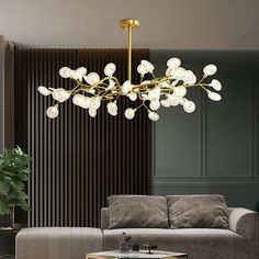 a living room with a couch, coffee table and chandelier hanging from the ceiling