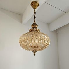 a chandelier hanging from the ceiling in a room with white walls and ceilings