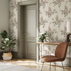 a room with a chair, table and wallpaper