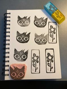 a notebook with some stamps on it next to a rubber stamp and a marker pen