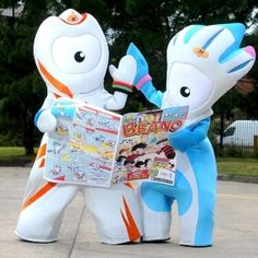 two inflatable cartoon characters are reading a news paper while standing next to each other