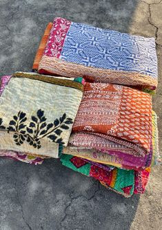 several different colored pieces of cloth sitting on the ground next to each other in rows