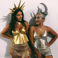 two women dressed in costumes standing next to each other with their faces painted gold and silver