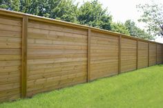 a wooden fence in the middle of a grassy field