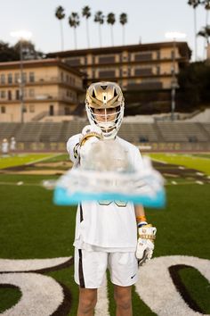 a person wearing a helmet and holding a ball in front of an empty football field