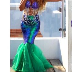 a woman in a green and blue mermaid costume is standing on a deck with her hands behind her head