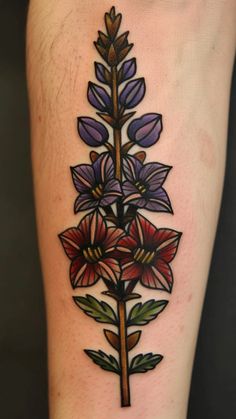 a tattoo with flowers on the leg and one flower that is purple, red and green