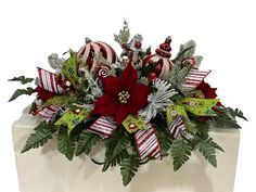 a christmas centerpiece with candy canes, poinsettia and greenery