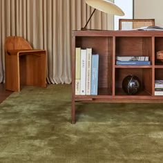 a bookshelf with many books on it in a living room next to a lamp