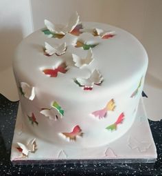 there is a white cake with butterflies on it