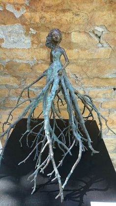 a sculpture of a woman with large, exposed roots