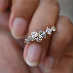 a woman's hand with three diamond rings on it