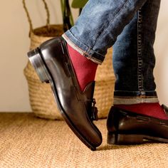 a person wearing red socks and black shoes