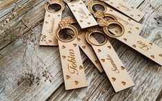 several wooden key chains with names and hearts on them sitting on top of a table