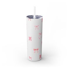 a white tumbler with pink bows on it and a straw sticking out of the lid