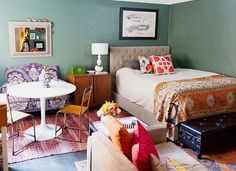 a living room filled with furniture and a white table in front of a blue wall