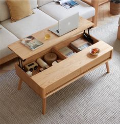 a living room with a couch, coffee table and laptop on top of the table