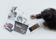 a woman laying on the floor with her head down and various pictures laid out next to her