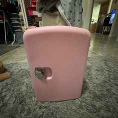 a pink refrigerator sitting on top of a carpet covered floor