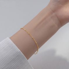 Our lightweight Minimal Satellite Chain Bracelet brings a fresh feel to your wardrobe. Simple and shimmery, this bracelet begs to be layered with others but can be worn alone for a minimal, polished look. DETAILS & SIZE Finish: 18K gold or rose gold plate, Sterling silver Material: .925 sterling silver Measurements: Beads: 2mm; Chain: 7" Lobster claw clasp Shop Bracelets for more options to layer it with! Complete the Look with the Matching Necklace! Minimalist Bangle Bracelet With Delicate Chain, Minimalist Delicate Chain Bangle Bracelet, Minimalist Gold Chain Bracelet With Simple Design, Gold Minimalist Chain Bracelet With Simple Design, Minimalist Yellow Gold Chain Bracelet With Delicate Chain, Minimalist Chain Bracelet With Adjustable Bangle, Minimalist Bangle Chain Bracelet With Adjustable Chain, Minimalist Adjustable Chain Bangle Bracelet, Minimalist Delicate Chain Paperclip Bracelet