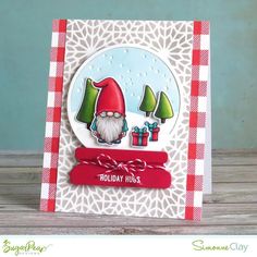 a handmade christmas card with a gnome and presents on the table next to it