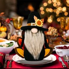 a table topped with plates and bowls filled with food next to a turkey head wearing a pilgrim's hat