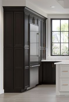 a large kitchen with black cabinets and white counter tops, along with an island in the middle