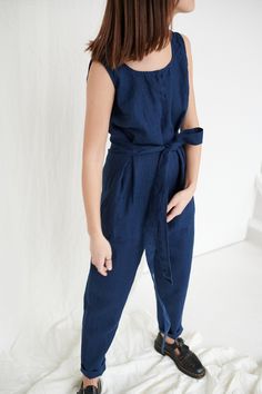 "The sleeveless jumpsuit Evelyn is one of our first jumpsuits, and it is so loved because if its simple cut. The deep V-neckline in the back and two attached waist ties give some charm to this figure-flattering silhouette. This garment is true to size, and we recommend choosing the size you usually wear. If you want the garment to be loose-fitting, choose a larger size than you usually wear. Before placing an order, check the approximate measurements of the finished garment given below. Model is Cotton Jumpsuit With Tie Waist And Relaxed Fit, Relaxed Fit Cotton Jumpsuits And Rompers With Tie Waist, Relaxed Fit Cotton Jumpsuit With Tie Waist, Fitted Linen Jumpsuits And Rompers With Pockets, Navy Jumpsuits And Rompers With Pockets, Relaxed Fit Jumpsuits And Rompers With Tie Waist, Navy Summer Overall Jumpsuit, Navy Jumpsuits And Rompers With Pockets For Spring, Navy Jumpsuits And Rompers For Work In Summer