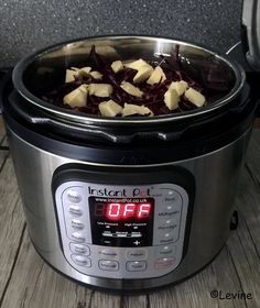 a crock pot filled with food sitting on top of a wooden table