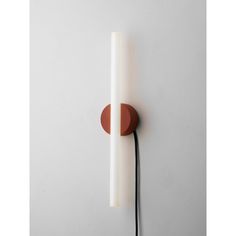 a white wall light with a red circle on the front and back of it's arm