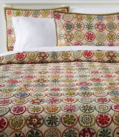 a bed with a colorful comforter and pillows