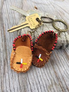 two little moccas are sitting on a wooden table with keys in the background