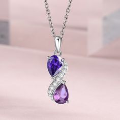 Step into a world of enchantment with this stunning necklace, adorned with two lustrous pear-cut purple stones, each exuding its unique shade and allure. Nestled between them, a radiant swirl of glistening white stones adds a touch of celestial brilliance, creating a harmonious dance of colors and light. Embrace the beauty of contrast and sophistication, let this exquisite piece be a symbol of your elegance and charm, a timeless treasure that captures the essence of grace and luxury.Carat Weight White Stones, Magical Jewelry, Round Necklace, Amethyst Purple, Purple Stones, Necklace Online, Stunning Necklace, Timeless Treasures, White Stone