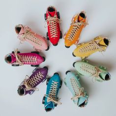 six pairs of colorful sneakers are arranged in a circle on a white surface, with one shoe facing the camera