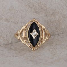 This ladies 10k yellow gold ring has one single cut diamond that measures 0.015ct and is SI1 clarity and I-J color. The onyx marquise shape is 12 mm x 6 mm. She has filigree design around the frame. The ring weighs 2.1 grams and the finger size is 5.25. Condition: Pre-Owned *All items are thoroughly inspected for quality assurance purposes Oval Diamond Jewelry With Black Enamel, Oval Black Enamel Diamond Jewelry, 14k Gold Marquise Jewelry With Diamond Accents, 14k Gold Jewelry With Diamond Accents In Marquise Shape, Anniversary Marquise Jewelry With Diamond Eyes, Marquise Jewelry With Diamond Eyes For Anniversary, Elegant Black Enamel Diamond Ring For Anniversary, Marquise Cut Jewelry With Diamond Eyes For Formal Occasions, Marquise Cut Diamond Eyes Jewelry For Formal Occasions