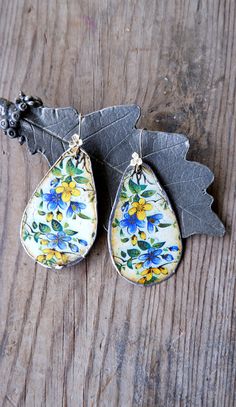 These delightful happy flower statement earrings are made with vintage tin. First it was sawed out from a vintage tin box and then it was gently hammered into shape. After that, it is sanded around so that it can be soldered. The backsides are cream colored. The tin shows marks of its age, but this does not take away any of its beauty. The ear wires are sterling silver. These are big! A total length of 2 7/8'' (7.5 cm) but very comfortable of weight. Due to the vintage tin a one of a kind. All metal is nickel and lead free, the ear wires are sterling silver (925). More vintage tin jewelry available in the shop: https://www.etsy.com/shop/StaroftheEast?ref=seller-platform-mcnav&search_query=tin Two shipping options: Registered airmail takes 15 - 30 days on average,it is cheap and safe but sl Vintage Flower Drop Earrings For Gift, Vintage Blue Flower Earrings, Vintage Nickel-free Enamel Earrings, Vintage Blue Flower Earrings Nickel Free, Vintage Blue Handmade Flower Earrings, Vintage Flower Shaped Nickel Free Earrings, Vintage Flower-shaped Nickel-free Earrings, Vintage Blue Flower Earrings, Nickel-free, Blue Vintage Flower Earrings Nickel-free