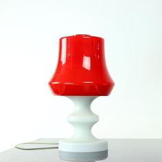 a red lamp sitting on top of a white table