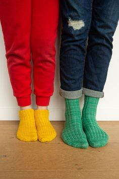 two people standing next to each other wearing colorful socks