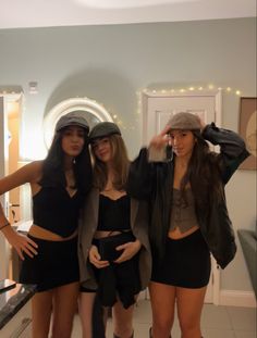 three women in short skirts and hats posing for the camera