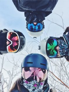 four people wearing ski goggles and snowboarding gear