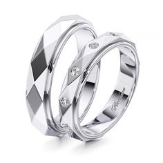 two white gold wedding rings with diamonds on each side and the words love is in the middle